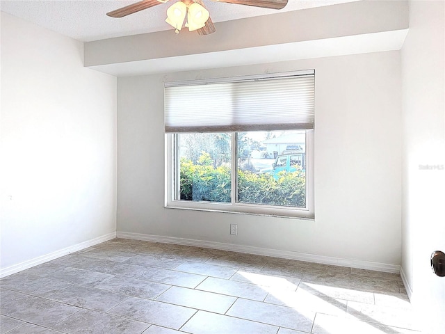 unfurnished room with ceiling fan and a textured ceiling