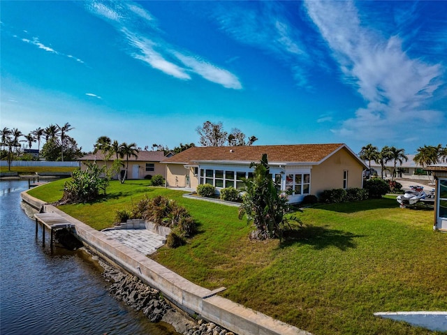 rear view of property with a lawn and a water view