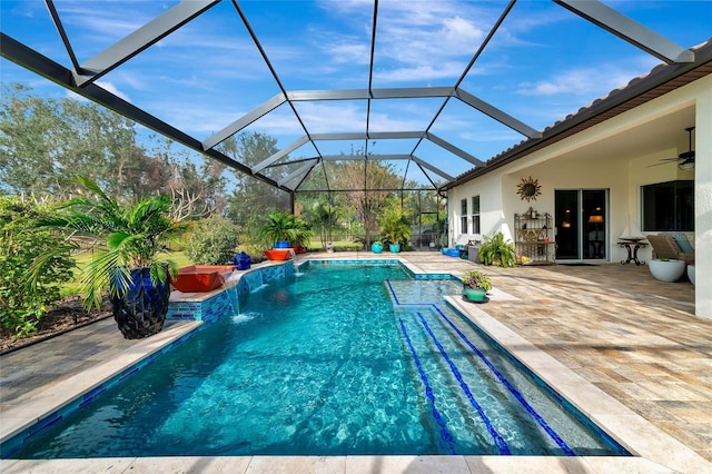 view of pool featuring pool water feature, glass enclosure, ceiling fan, and a patio area