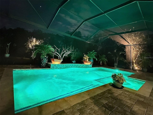 view of swimming pool with a patio and glass enclosure