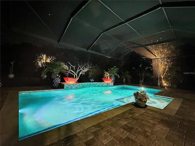 view of swimming pool featuring a patio area and a lanai