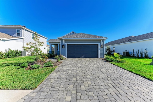 ranch-style house with a front yard, central AC, and a garage