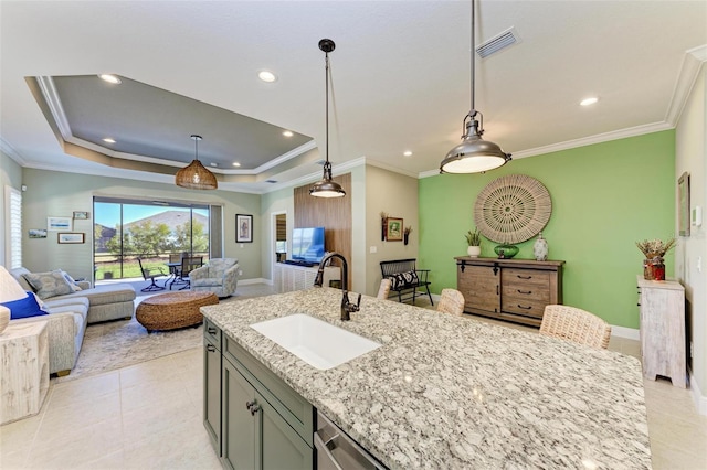 kitchen with light stone counters, pendant lighting, a raised ceiling, crown molding, and sink