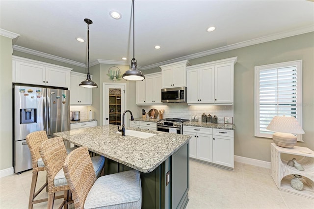 kitchen with a center island with sink, sink, stainless steel appliances, and white cabinets