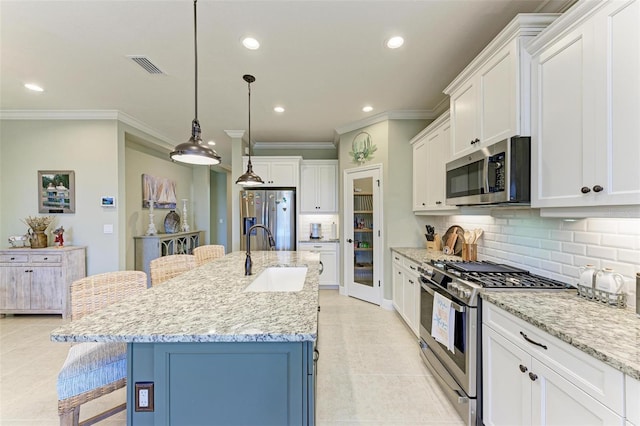 kitchen with a kitchen island with sink, a breakfast bar, hanging light fixtures, sink, and appliances with stainless steel finishes