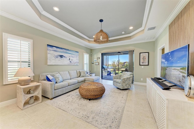 tiled living room featuring a tray ceiling and ornamental molding