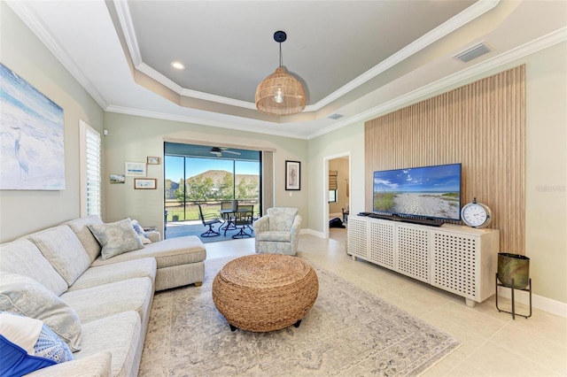 living room with ornamental molding, tile patterned flooring, and a raised ceiling