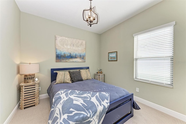 carpeted bedroom with an inviting chandelier