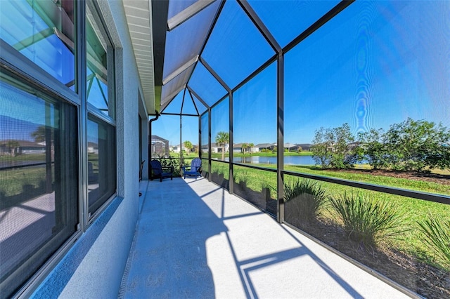 view of patio featuring a water view and glass enclosure