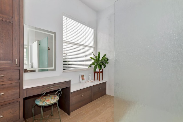 bathroom with a shower, vanity, and plenty of natural light