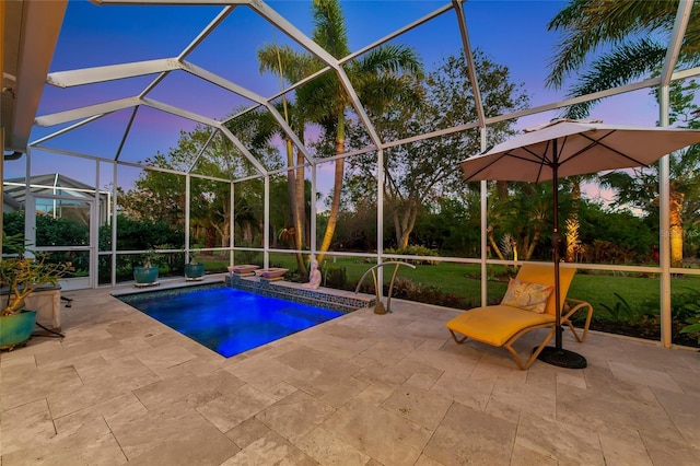 pool at dusk featuring a yard, glass enclosure, and a patio area