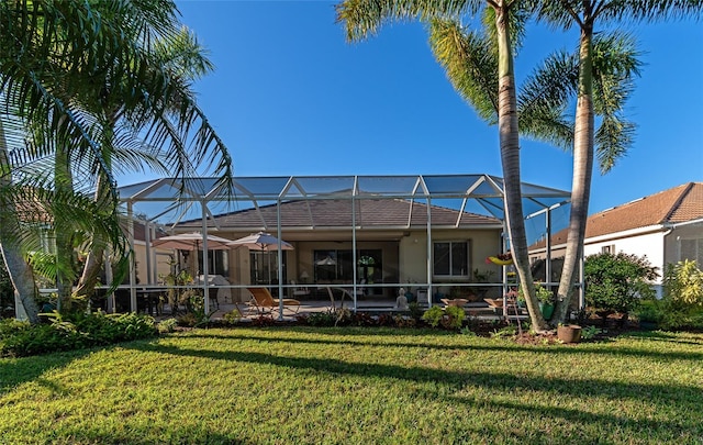 back of house with a yard and a lanai