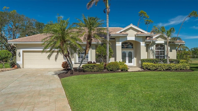 mediterranean / spanish house with a garage and a front yard