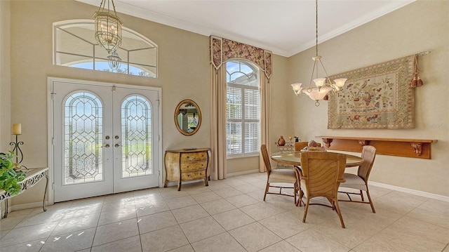 tiled dining space featuring an inviting chandelier, ornamental molding, and french doors