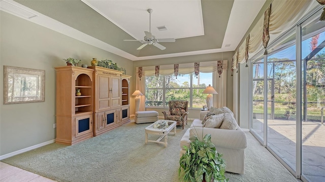 carpeted living room featuring a raised ceiling and ceiling fan