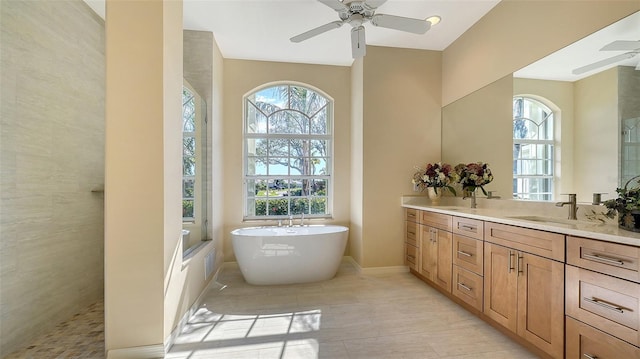 bathroom featuring vanity, a wealth of natural light, ceiling fan, and a bathtub