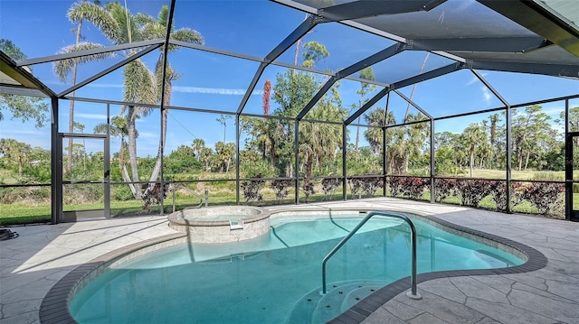 view of pool featuring an in ground hot tub, a patio, and glass enclosure