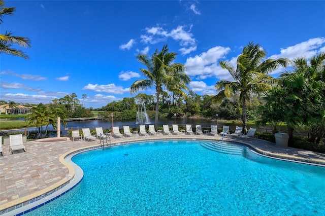 view of pool with a patio area and a water view