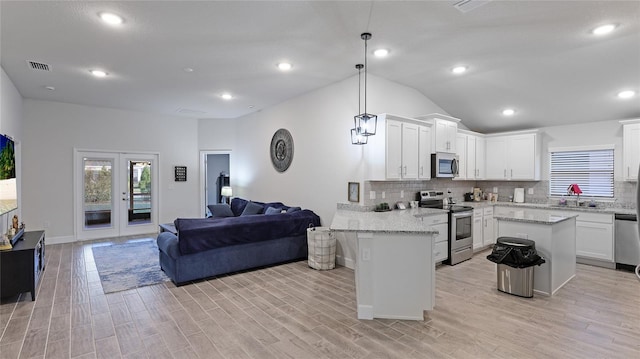 kitchen with pendant lighting, white cabinetry, backsplash, and appliances with stainless steel finishes