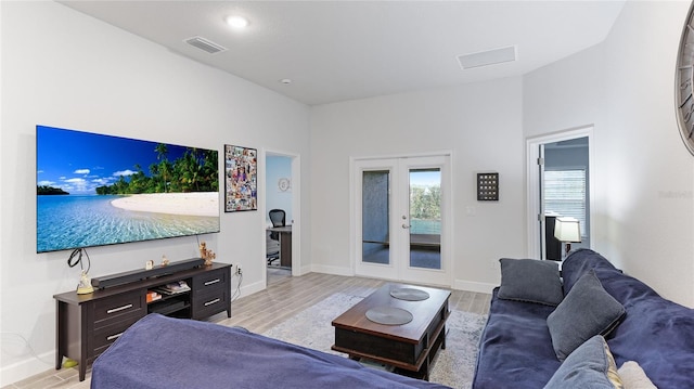 living room with french doors and light hardwood / wood-style floors