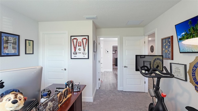 workout area featuring light carpet and a textured ceiling