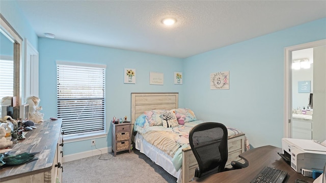 carpeted bedroom with a textured ceiling and ensuite bathroom