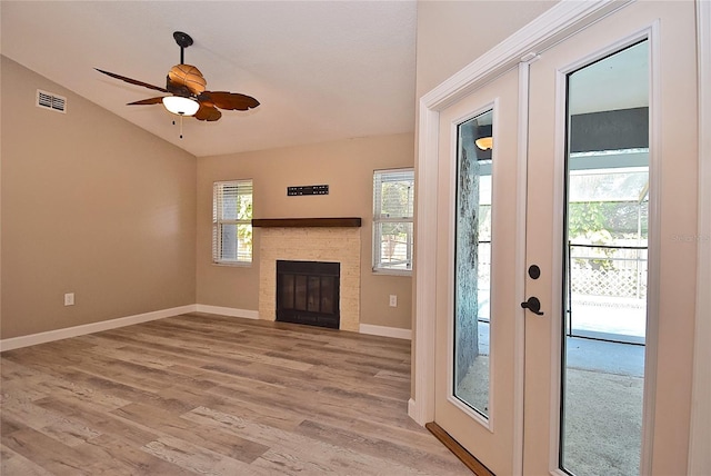 unfurnished living room featuring ceiling fan, wood-type flooring, lofted ceiling, and a wealth of natural light