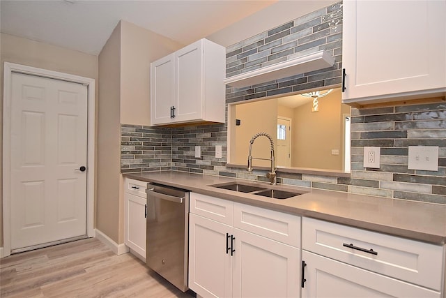 kitchen featuring white cabinetry, sink, stainless steel dishwasher, backsplash, and light wood-type flooring