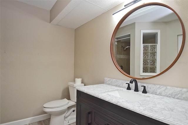 bathroom with hardwood / wood-style floors, vanity, toilet, and a shower