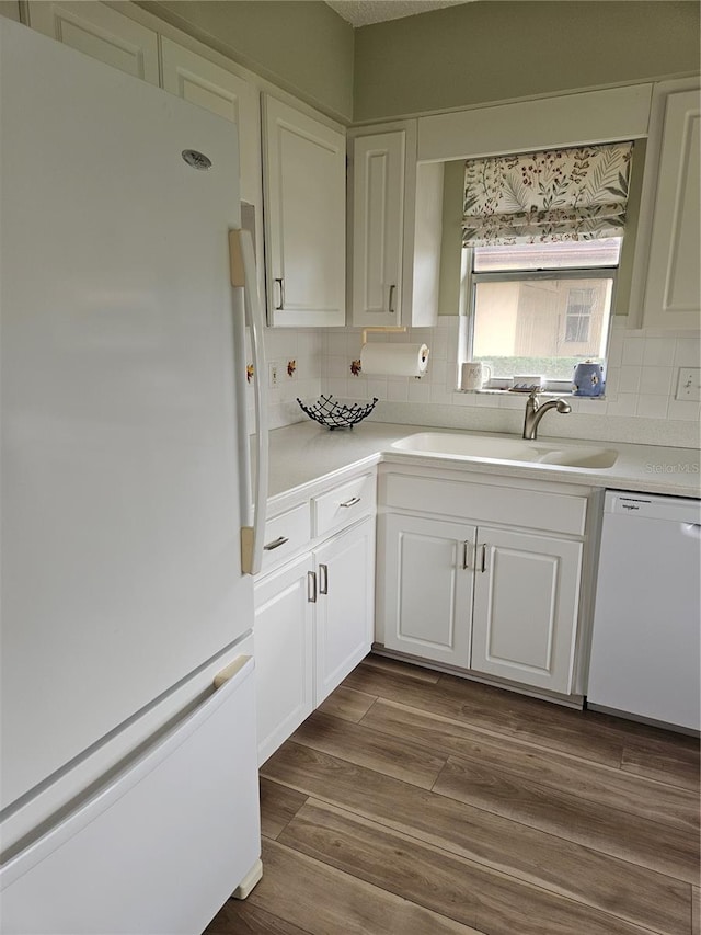 kitchen featuring white cabinetry, wood-type flooring, white appliances, and sink