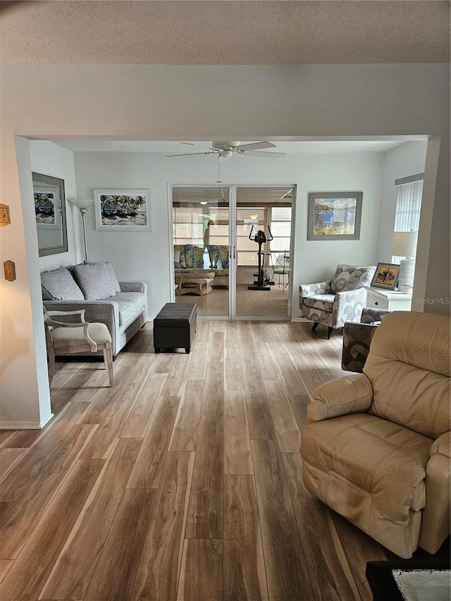 living room featuring hardwood / wood-style floors, a textured ceiling, and ceiling fan