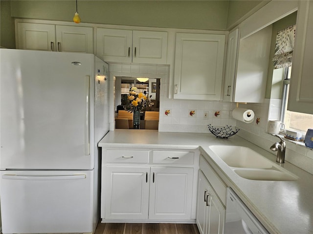 kitchen featuring white appliances, white cabinets, sink, decorative backsplash, and dark hardwood / wood-style flooring