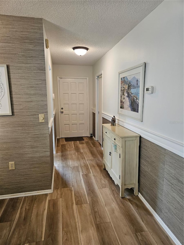 doorway featuring wood-type flooring and a textured ceiling