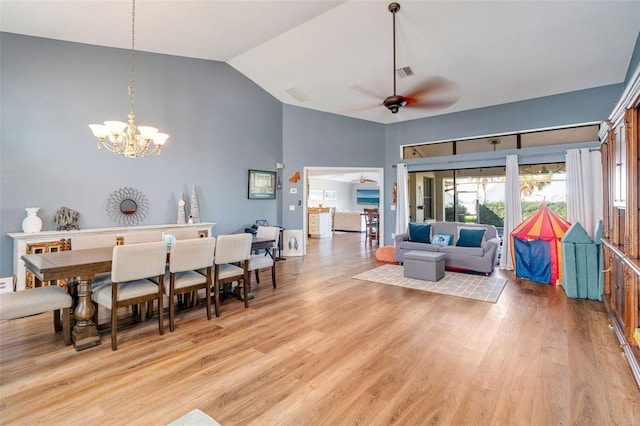 dining space featuring hardwood / wood-style floors, ceiling fan with notable chandelier, and lofted ceiling