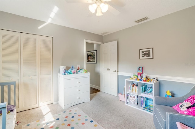 carpeted bedroom with ceiling fan and a closet