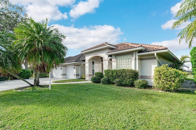 mediterranean / spanish house featuring a garage and a front lawn