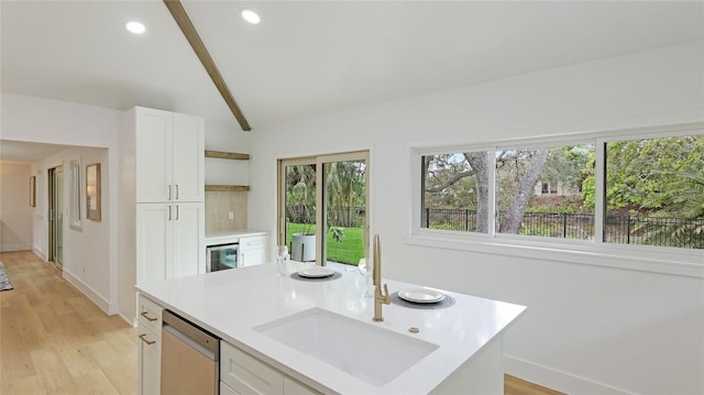 kitchen with white cabinetry, sink, vaulted ceiling, and dishwasher