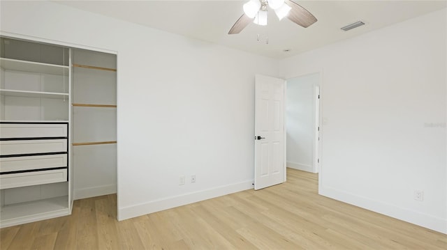 unfurnished bedroom featuring ceiling fan, light hardwood / wood-style floors, and a closet