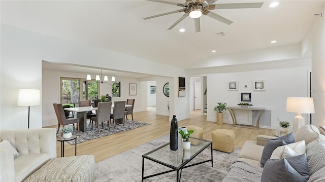 living room with recessed lighting, lofted ceiling, ceiling fan with notable chandelier, and light wood-type flooring
