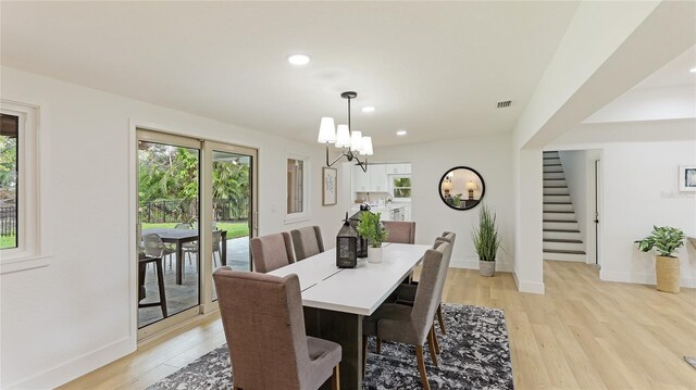 dining area with stairway, a healthy amount of sunlight, and light wood-type flooring