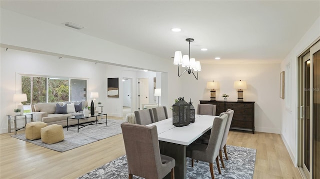dining area with light wood-style floors, visible vents, baseboards, and a notable chandelier