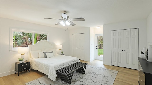 bedroom featuring multiple closets, light wood-style flooring, and multiple windows