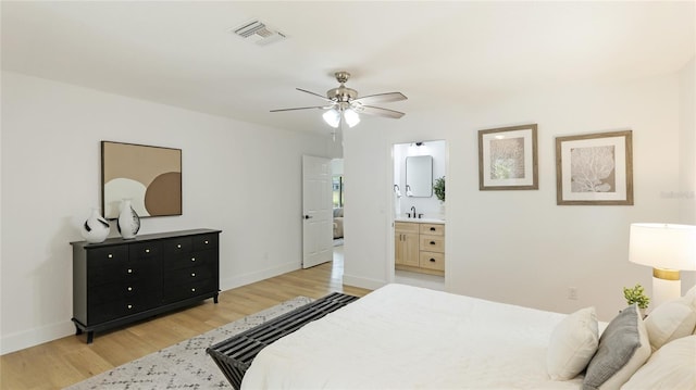 bedroom with baseboards, a sink, visible vents, and light wood-type flooring