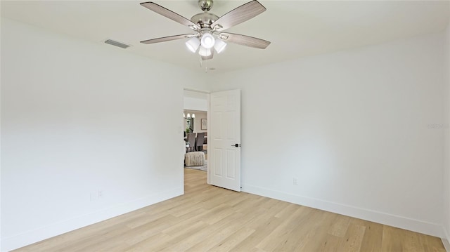 empty room with visible vents, light wood finished floors, baseboards, and ceiling fan