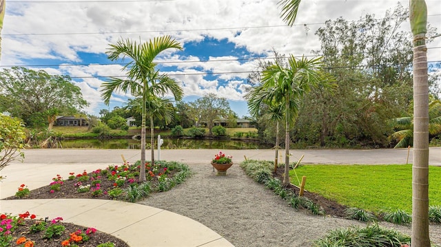 view of home's community with a yard and a water view