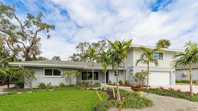 view of front of house with a front lawn, driveway, fence, a garage, and stucco siding