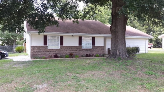 ranch-style house featuring brick siding and a front lawn