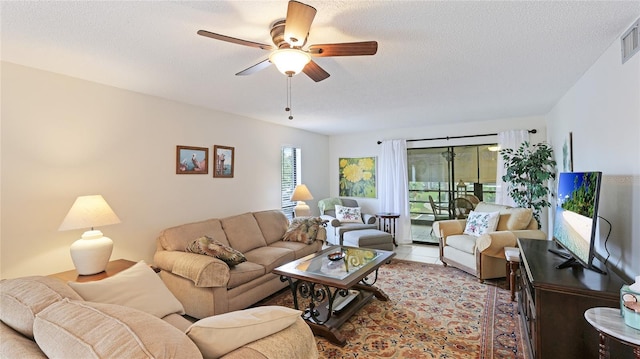 living room with ceiling fan and a textured ceiling