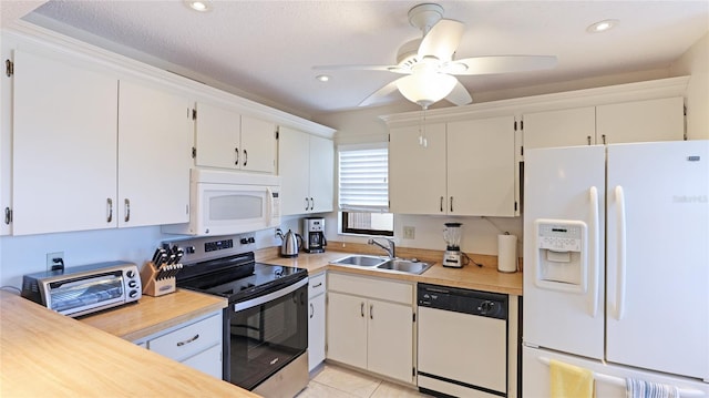 kitchen with white appliances, sink, ceiling fan, light tile patterned floors, and white cabinetry