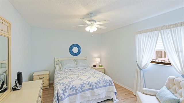 bedroom featuring a textured ceiling, light hardwood / wood-style flooring, and ceiling fan